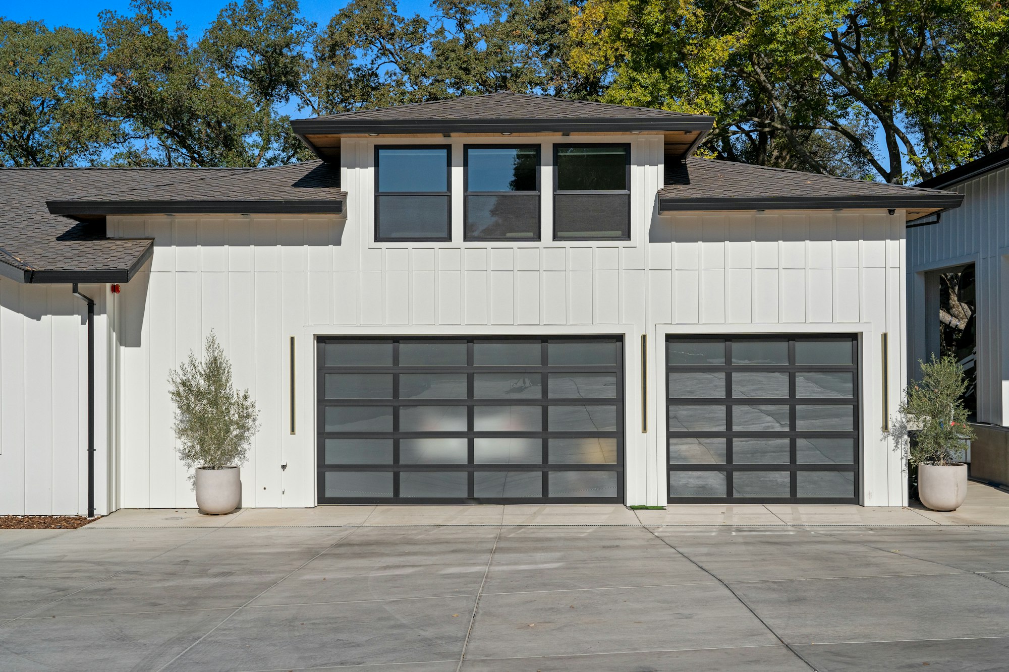 Two glass-panel garage doors on a white house
